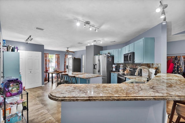 kitchen featuring a sink, a peninsula, a breakfast bar area, and stainless steel appliances