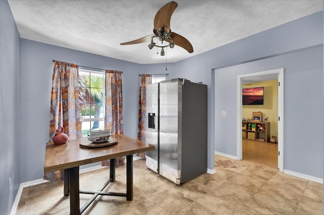 dining room with a ceiling fan, baseboards, and a textured ceiling