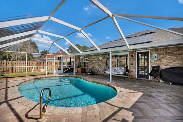 view of pool with fence, glass enclosure, a grill, a fenced in pool, and a patio area