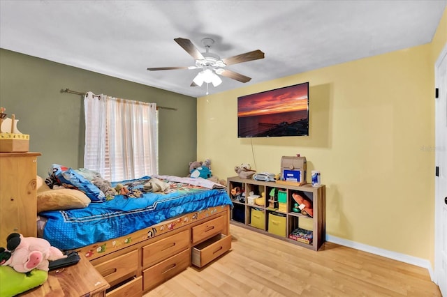 bedroom with baseboards, ceiling fan, and light wood finished floors