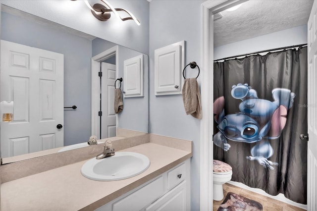 bathroom featuring a textured ceiling, vanity, and toilet