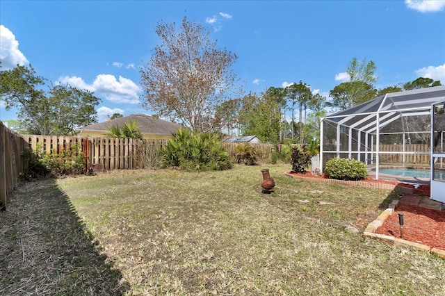 view of yard featuring glass enclosure, a fenced backyard, and a fenced in pool