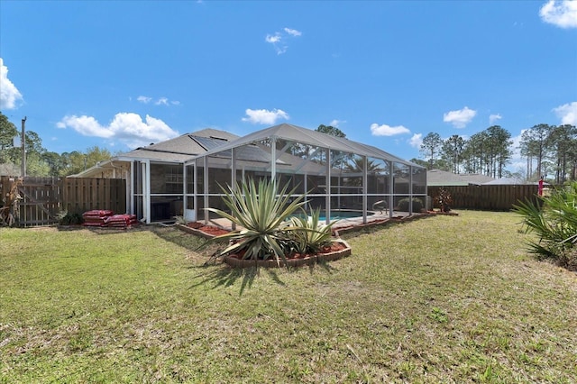 view of yard featuring glass enclosure, a fenced backyard, and a fenced in pool