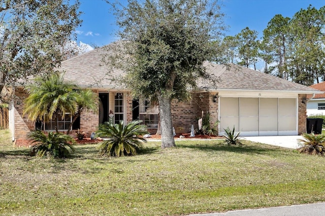 view of front of property with driveway, a front lawn, roof with shingles, an attached garage, and brick siding