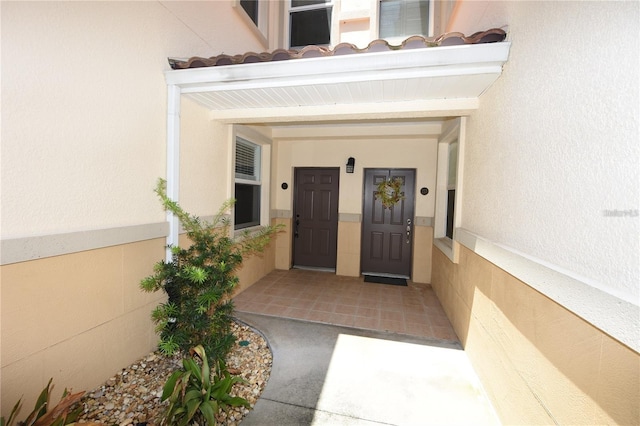 property entrance featuring stucco siding and a tiled roof