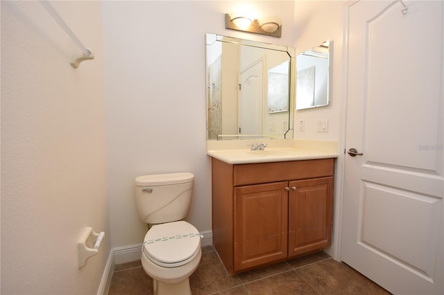 bathroom with vanity, tile patterned floors, toilet, and baseboards