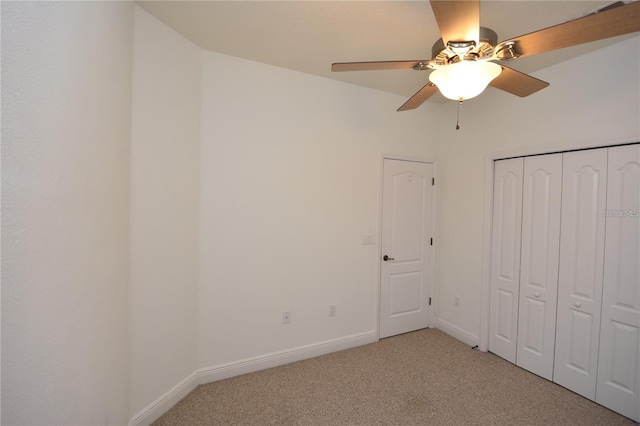 unfurnished bedroom with a ceiling fan, baseboards, a closet, and light carpet