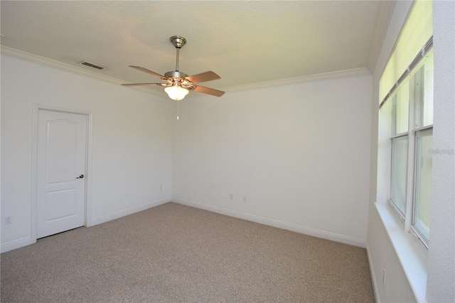 unfurnished room featuring visible vents, light colored carpet, ceiling fan, and ornamental molding