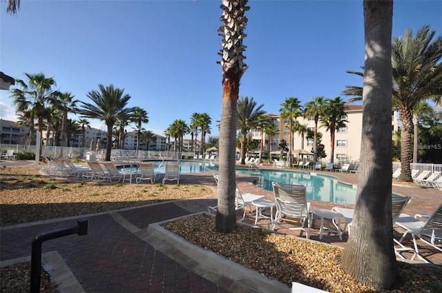 community pool featuring fence and a patio area