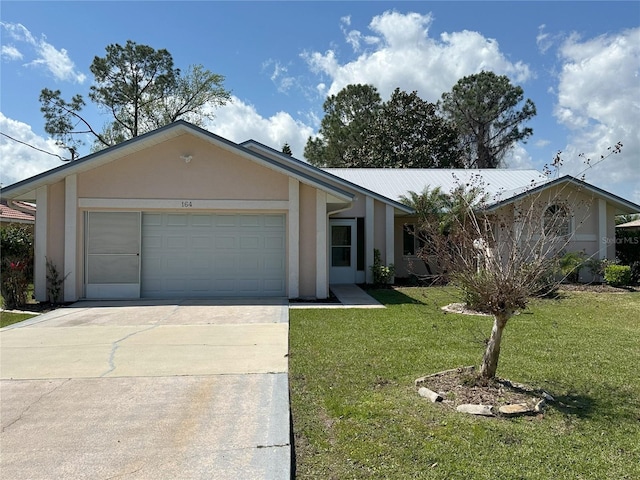 view of front of home featuring a front yard, an attached garage, stucco siding, concrete driveway, and metal roof