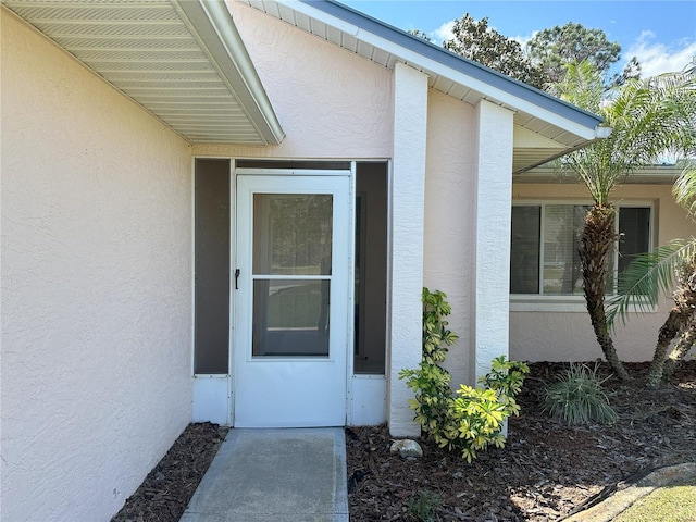 view of exterior entry with stucco siding