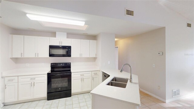 kitchen with a sink, visible vents, black appliances, and a peninsula