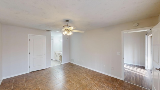 empty room featuring visible vents, baseboards, and a ceiling fan