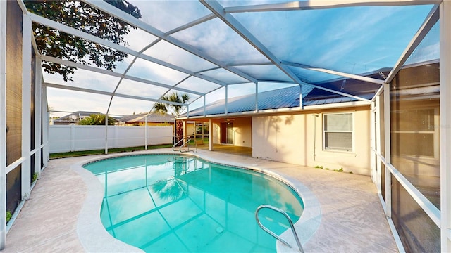 view of swimming pool with glass enclosure, a fenced in pool, a patio area, and fence