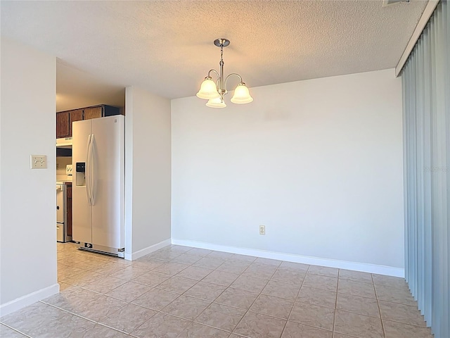 empty room featuring baseboards, light tile patterned floors, a textured ceiling, and an inviting chandelier