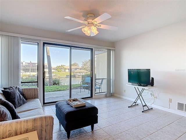 living room featuring light tile patterned flooring, baseboards, visible vents, and ceiling fan