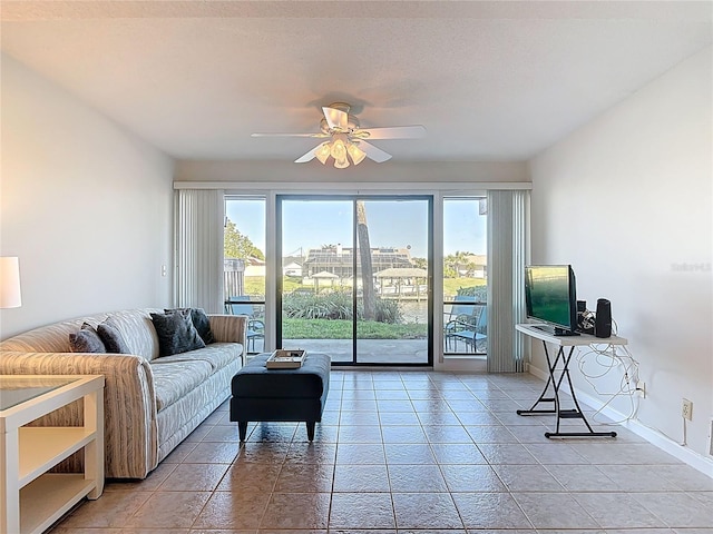 living area with plenty of natural light, baseboards, and ceiling fan