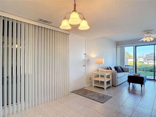 living room featuring light tile patterned floors, visible vents, and ceiling fan