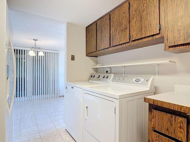 washroom featuring a textured ceiling, a chandelier, light tile patterned flooring, and washing machine and clothes dryer