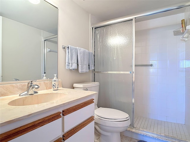 bathroom featuring toilet, a stall shower, and vanity