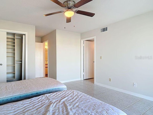 tiled bedroom featuring baseboards, visible vents, a closet, and ceiling fan