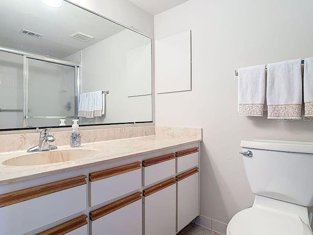 bathroom with visible vents, vanity, toilet, and a shower stall