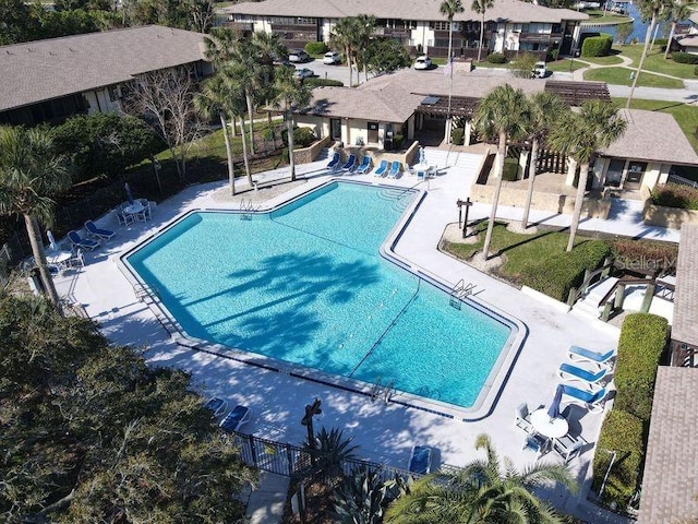 pool with a patio, fence, and a residential view