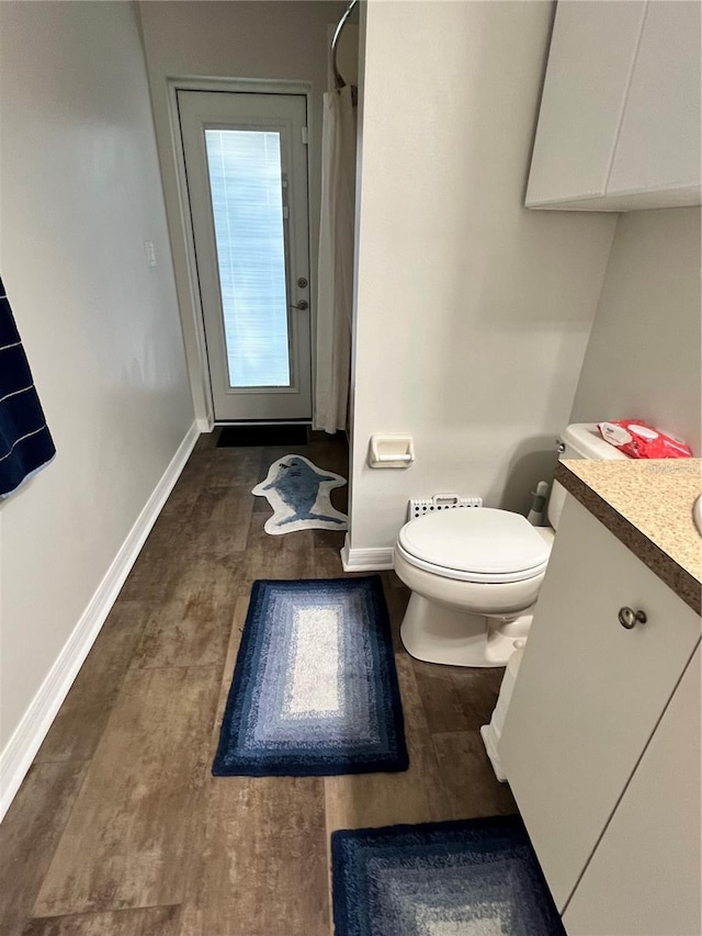 full bath featuring a shower with curtain, toilet, vanity, and baseboards