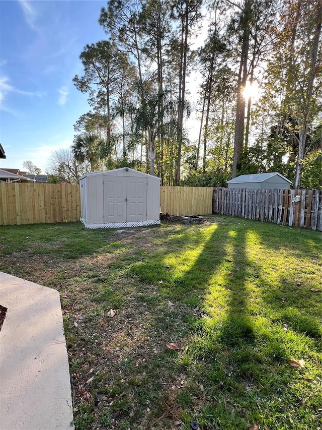 view of yard with an outbuilding, a fenced backyard, and a shed