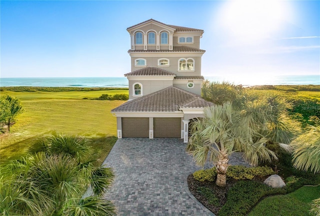 52 Hammock Beach Cir S, Palm Coast, FL 32137 - coastal inspired home featuring a tile roof, a garage, stucco siding, a water view, and decorative driveway