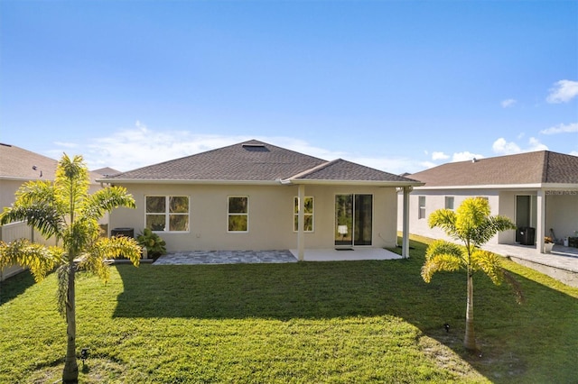 rear view of house with a patio, a yard, and stucco siding