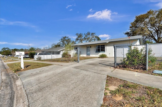 single story home featuring a fenced front yard, driveway, and a garage