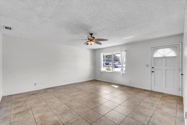 foyer entrance featuring baseboards, a ceiling fan, visible vents, and a textured ceiling