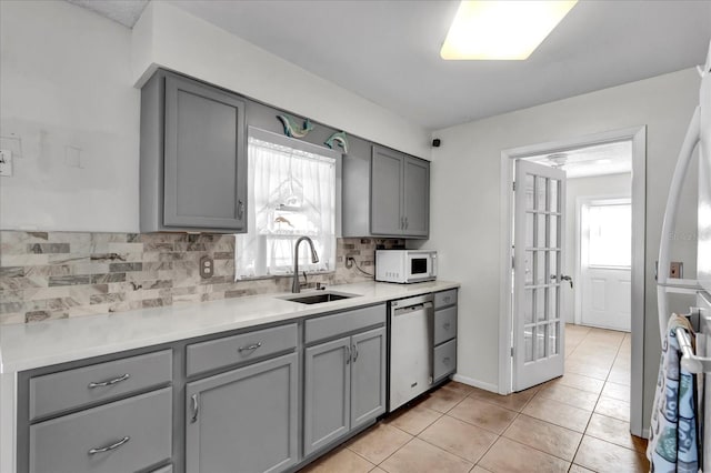 kitchen featuring a sink, white appliances, and gray cabinets