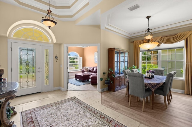 dining space with visible vents, ornamental molding, light tile patterned floors, and a tray ceiling