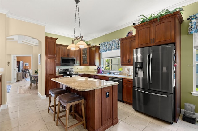 kitchen featuring decorative backsplash, light tile patterned flooring, a center island, a sink, and appliances with stainless steel finishes