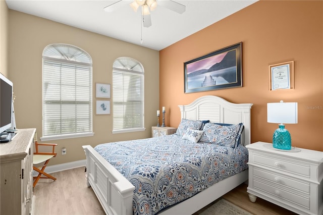 bedroom featuring baseboards, a ceiling fan, and light wood finished floors