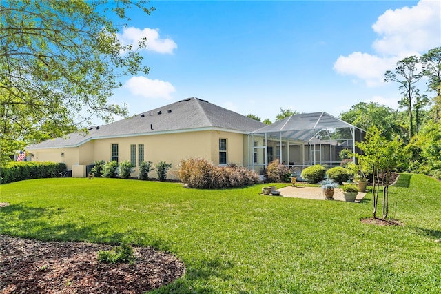 rear view of house featuring a lawn, a patio, stucco siding, and glass enclosure