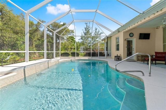 outdoor pool with glass enclosure and a patio area
