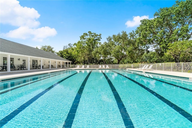 community pool with fence and a patio