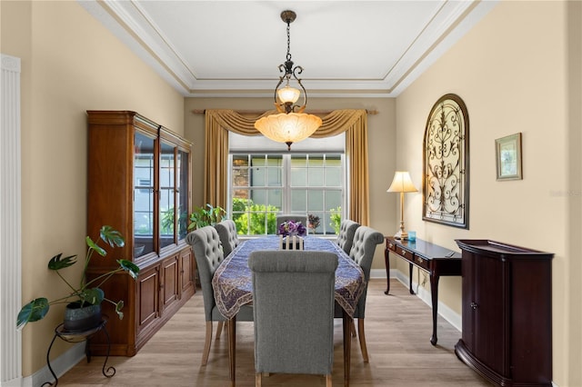 dining area with crown molding, light wood finished floors, and baseboards