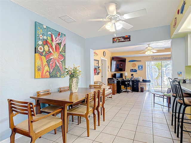 dining room with light tile patterned floors, visible vents, and a ceiling fan
