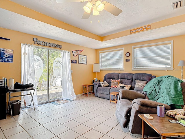living room with visible vents, plenty of natural light, a textured ceiling, and ceiling fan