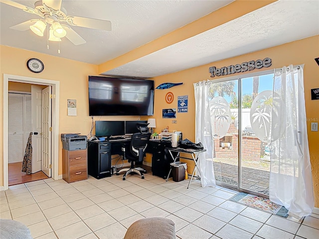 office featuring ceiling fan, baseboards, a textured ceiling, and light tile patterned flooring