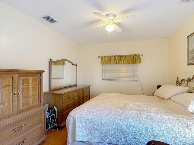 bedroom featuring wood finished floors, visible vents, and ceiling fan