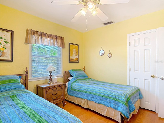 bedroom featuring wood finished floors, visible vents, and ceiling fan