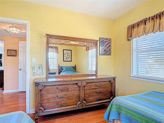bedroom with baseboards and wood finished floors