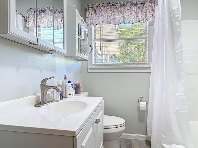 full bath with vanity, a shower with curtain, wood finished floors, baseboards, and toilet