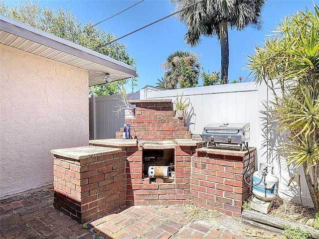 view of patio / terrace with a grill and fence