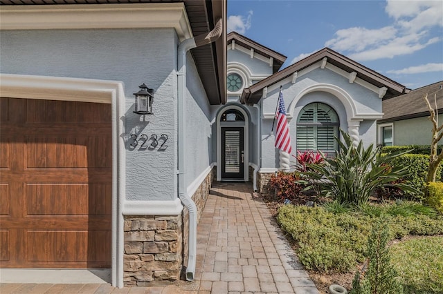 view of exterior entry with stone siding and stucco siding